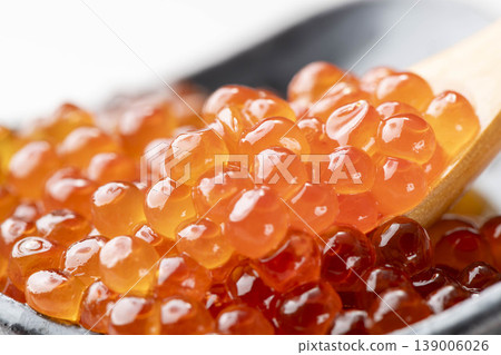 A close-up of salmon roe marinated in soy sauce, served on a spoon. The plump, glistening salmon eggs are beautiful, and it's high-quality salmon roe from Hokkaido. A close-up of salmon roe marinated in soy sauce, served on a spoon. The plump, glistening salmon eggs are beautiful, and it's high-quality salmon roe from Hokkaido. 139006026