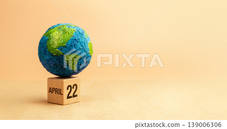 Globe on wooden block marked April 22 representing Earth Day awareness 139006306