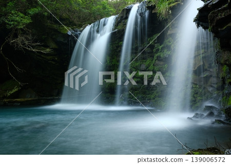 A beautiful waterfall appears in the middle of the forest, with a silky flow and moss-covered rock face. A beautiful waterfall appears in the middle of the forest, with a silky flow and moss-covered rock face. 139006572