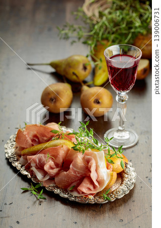 Prosciutto with pears and thyme on a silver tray. 139006731