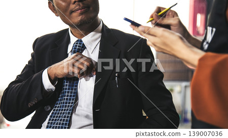 Businessman taking payment while waitress records order on smartphone, cashless transaction concept in cafe, showcasing digital payment, customer service and modern business interaction 139007036