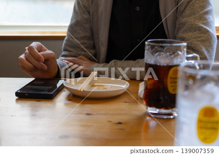 一名男子在酒吧使用智慧型手機。 139007359