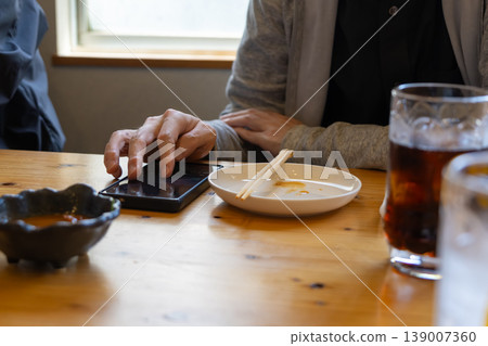 一名男子在酒吧使用智慧型手機。 139007360