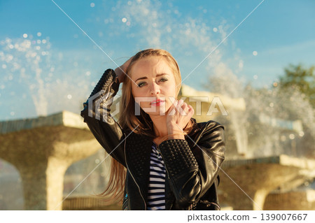woman casual style posing against city fountain 139007667