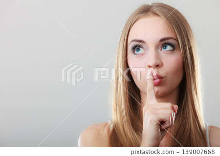 Woman asking for silence finger on lips 139007668