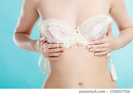 Naked woman dressing up her bra. Naked woman dressing up her bra. 139007708