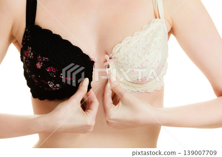 Lady with choice trying to choose perfect bra. Lady with choice trying to choose perfect bra. 139007709