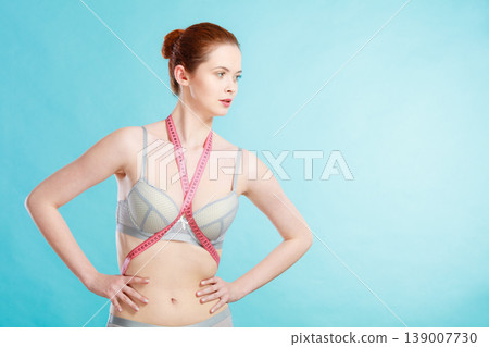 Woman in underwear with measure tape 139007730