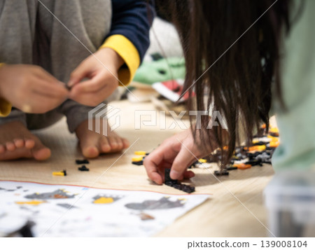 當孩子們坐在地板上玩耍時,他們的手在地板上跳動。 當孩子們坐在地板上玩耍時,他們的手在地板上跳動。 139008104