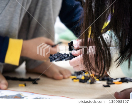 當孩子們坐在地板上玩耍時,他們的手在地板上跳動。 當孩子們坐在地板上玩耍時,他們的手在地板上跳動。 139008107