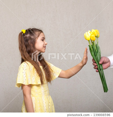 Young girl refusing a yellow tulip bouquet with a hand gesture, showing consent and boundaries Young girl refusing a yellow tulip bouquet with a hand gesture, showing consent and boundaries 139008596