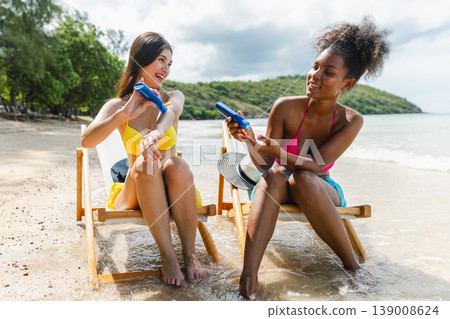 Two women relax on beach chairs by the sea 139008624