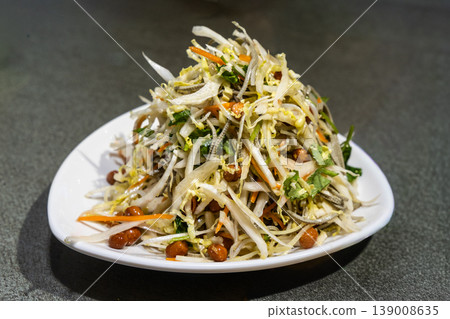 Serving of Chinese specialty cold salad with cabbage and groundnuts as appetizer. 139008635