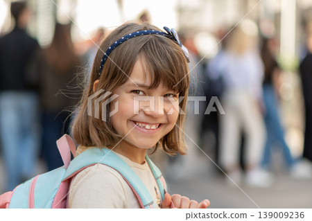 Girl age 7 smiling on city street among people Girl age 7 smiling on city street among people 139009236