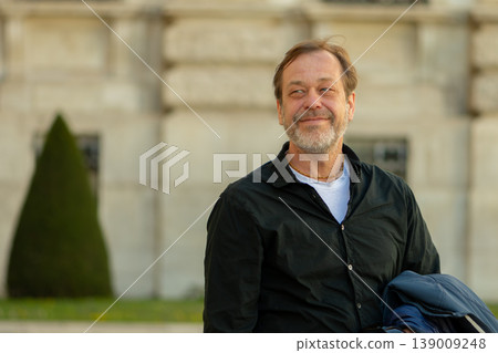 Man 50-55 years old looking aside showing confidence calm control and positive mood outdoors 139009248