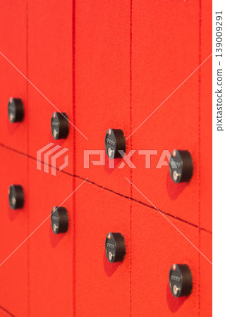 Storage lockers with code locks placed on bright red wall in modern interior Storage lockers with code locks placed on bright red wall in modern interior 139009291
