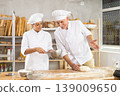Elderly man and woman kneading and whipping dough 139009650