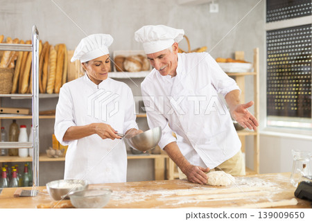 Elderly man and woman kneading and whipping dough Elderly man and woman kneading and whipping dough 139009650