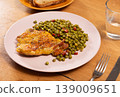 Delicious crispy chicken with peas as a side dish on a plate 139009651
