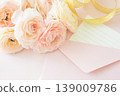 A bouquet of pink ranunculus flowers, along with an envelope and memo card. 139009786