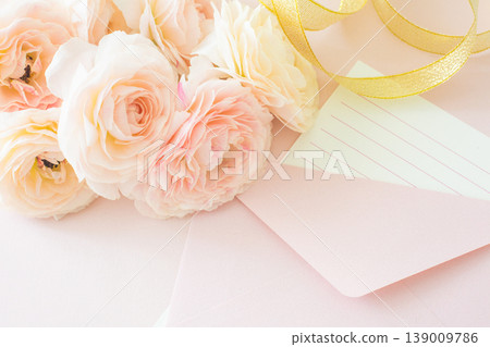 一束粉紅色的毛茛花，外加一個信封和一張留言卡。 139009786