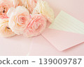A bouquet of pink ranunculus flowers, along with an envelope and memo card. 139009787