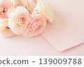 A bouquet of pink ranunculus flowers, along with an envelope and memo card. 139009788