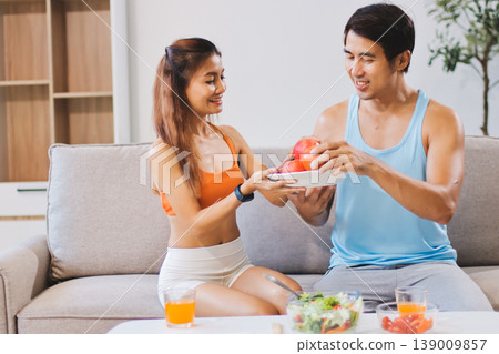 A happy couple prepares fresh vegetables, laughing and enjoying cooking a healthy meal together. A happy couple prepares fresh vegetables, laughing and enjoying cooking a healthy meal together. 139009857