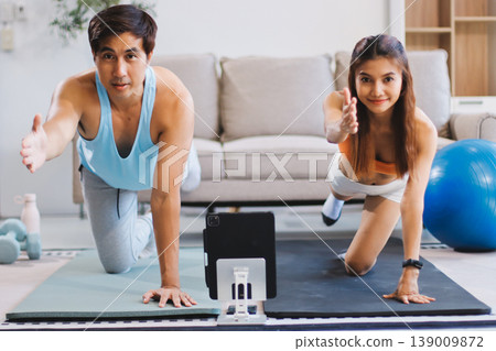 Support, teamwork and fitness couple doing workout training, challenging exercise for endurance, strength and stamina in a gym. Active, fit man and woman giving support and motivation during pushup Support, teamwork and fitness couple doing workout training, challenging exercise for endurance, strength and stamina in a gym. Active, fit man and woman giving support and motivation during pushup 139009872