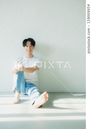 A man in denim sitting on the floor 139009954