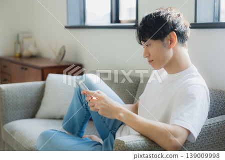 Young man looking at a smartphone Young man looking at a smartphone 139009998