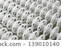 White plastic rollers of industrial conveyor, production, sorting, or transportation line 139010140