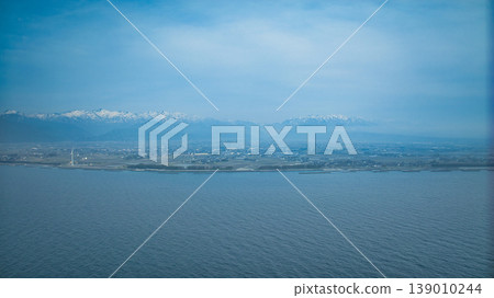 A hazy landscape of offshore breakwaters, seawalls, and windbreaks around the Shimoshinkawa coast in eastern Toyama Prefecture. 139010244