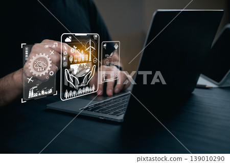 Hands interacting with digital ecological icons on a laptop in a modern workspace, illustrating technology and sustainability concepts for stock photography Hands interacting with digital ecological icons on a laptop in a modern workspace, illustrating technology and sustainability concepts for stock photography 139010290
