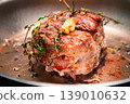 Beef roast with herbs cooking in a stainless steel pan on a stovetop 139010632