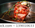 Beef roast with herbs and garlic in a frying pan, ready for cooking 139010633