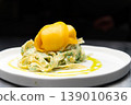 Fresh pasta dish topped with mango puree and green herb sauce 139010636