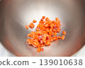 Diced salmon pieces in stainless steel mixing bowl for culinary preparation 139010638