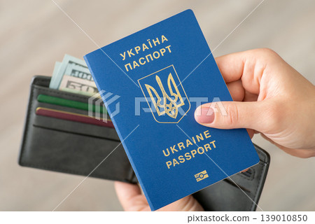 Passport of Ukrainian person near wallet with dollar bills. Immigration concept, travel to USA Passport of Ukrainian person near wallet with dollar bills. Immigration concept, travel to USA 139010850