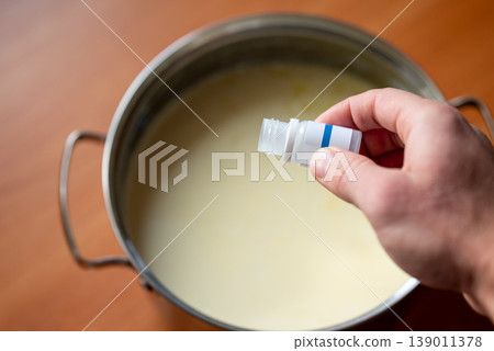 Putting ferment into milk in order to make yogurt, close up. Home cooking, diary product, good for health concepts 139011378