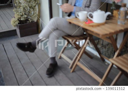 A man with a smartphone at a street cafe table. A man with a smartphone at a street cafe table. 139011512