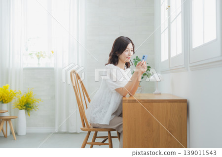 A woman watching a smartphone A woman watching a smartphone 139011543
