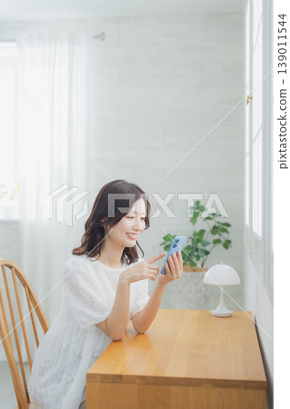 A woman watching a smartphone A woman watching a smartphone 139011544