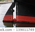 Close-up of the ship's hull floating on the water and its waterline markings. 139011749