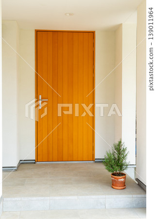 The front door of a house and potted plants The front door of a house and potted plants 139011964
