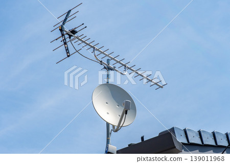 Television antennas and BS/CS parabolic antennas installed on the roofs of houses Television antennas and BS/CS parabolic antennas installed on the roofs of houses 139011968