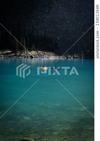 Canoeing amidst the mystical beauty of Moraine Lake, a breathtaking turquoise blue landscape. Canoeing amidst the mystical beauty of Moraine Lake, a breathtaking turquoise blue landscape. 139013686
