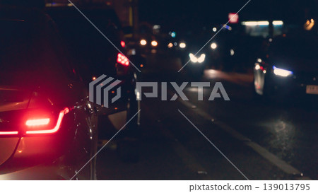 Abstract and blurred rear side of cars turn on brake light. Opposite road with many cars driving past thong at night. Abstract and blurred rear side of cars turn on brake light. Opposite road with many cars driving past thong at night. 139013795