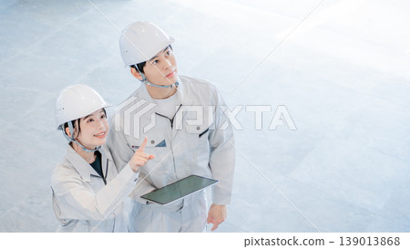 一名身穿工作服的男子和一名女子正在進行調查 一名身穿工作服的男子和一名女子正在進行調查 139013868