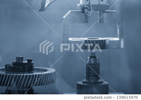 High-technology robotic arm performing material handling of precision bevel gear parts in a smart factory. High-technology robotic arm performing material handling of precision bevel gear parts in a smart factory. 139013970